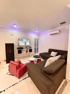 ein Wohnzimmer mit einem Sofa und einem TV in der Unterkunft 吉胆街坊民宿street Homes Inn Pulau Ketam in Bagan Pulau Ketam