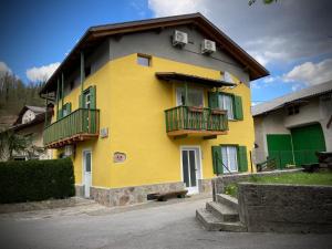 a yellow building with balconies on the side of it at Farmhouse Cvetje in Tolmin