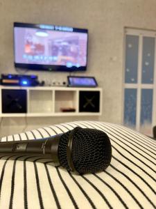 a microphone sitting on top of a bed with a television at 吉胆街坊民宿street Homes Inn Pulau Ketam in Bagan Pulau Ketam