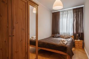 a bedroom with a bed and a large mirror at 11 apart in Gdynia