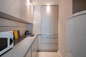 a kitchen with white cabinets and a microwave at 11 apart in Gdynia