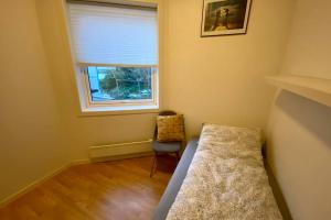 a small room with a bed and a window at Nice and central apartment in quiet area in Ålesund