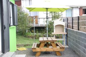 einen Picknicktisch und einen Regenschirm auf einer Terrasse in der Unterkunft l'an dormi vacances in La Plaine des Cafres