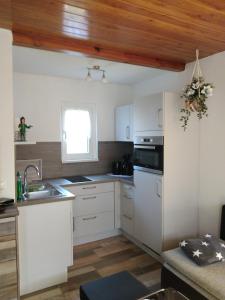 eine Küche mit weißen Schränken und einer Holzdecke in der Unterkunft Am Schwielochsee 2 in Speichrow