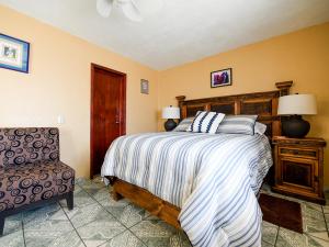 um quarto com uma cama grande e uma cadeira em Posada Las Reynas by Rotamundos em Mineral de Pozos