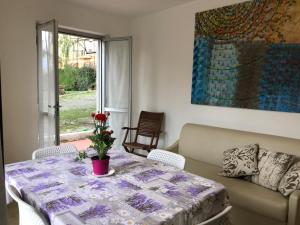 uma sala de estar com uma mesa e um sofá em Le Villette di Villa Paola em Loano