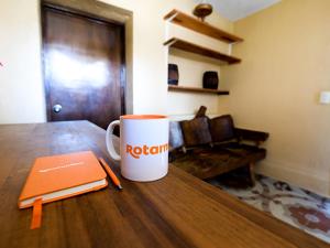 una taza de café sobre una mesa de madera con un cuaderno en Posada Las Reynas by Rotamundos, en Mineral de Pozos