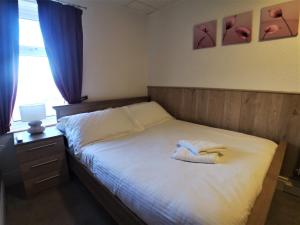 ein Schlafzimmer mit einem Bett mit zwei Handtüchern darauf in der Unterkunft The Hopton Hotel in Blackpool