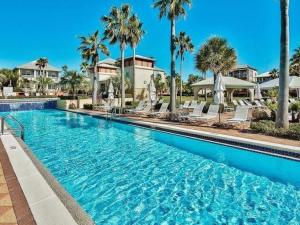 a large swimming pool with chairs and palm trees at 248 Beach Bike Way in Inlet Beach