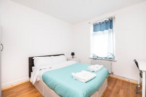 a bedroom with a bed with two towels on it at Dagenham Self catering House for Larger Groups with Free Parking in Dagenham