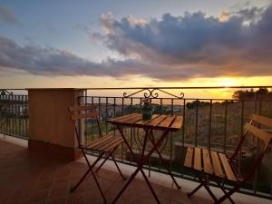 a table and chairs on a balcony with a sunset at La Dolce Dimora in Praia a Mare +40 photos
