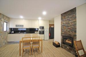 Una sala de estar con una mesa y una chimenea. en Casa da Fatinha by Gerês Casas, en Terras de Bouro 24 fotos más