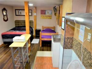 Habitación pequeña con cama y mesa en Hostal Mi Maravilla, en La Serena