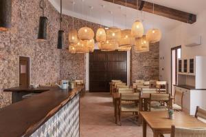 um restaurante com um bar e mesas e cadeiras de madeira em Quinta do Freixo em Benafim