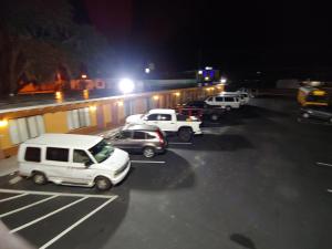 um grupo de carros estacionados num parque de estacionamento à noite em Relax Inn Silver Springs em Silver Springs