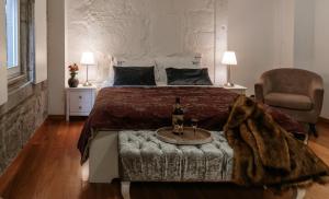 a bedroom with a bed and a table with a bottle of wine at Authentic Porto Apartments in Porto