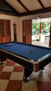 a pool table in a living room with a pool at Hotel Bugabutik in Puerto Viejo