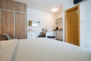 a bedroom with a large bed and a kitchen at Apartmani IVA in Neum