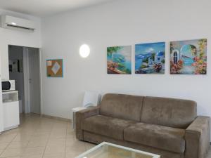 a living room with a couch and paintings on the wall at Residence Eurotel da Nella e Stefano in Rapallo