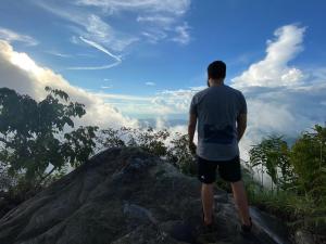 un hombre parado en una roca mirando al cielo en Monte La MaMa Ecolodge en Viotá