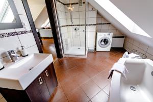 a bathroom with a sink and a washing machine at Apartament Stylowy in Leszno +8 photos