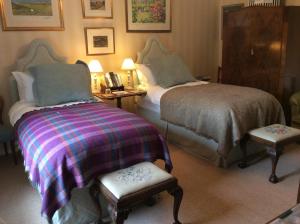 una camera d'albergo con due letti e una sedia di Ingram House Bed & Breakfast ad Alnwick
