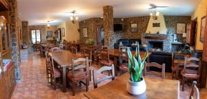 グエハル・シエラにあるHotel Rural Fuente La Tejaのテーブルと椅子、暖炉のあるレストラン
