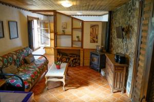 a living room with a couch and a stove at Hotel Rural Fuente La Teja in Güéjar-Sierra