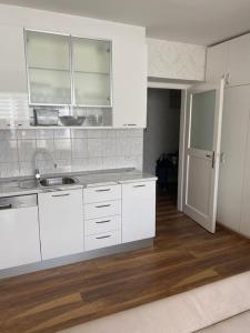 een keuken met witte kasten en een houten vloer bij Iva Apartment Split in Split