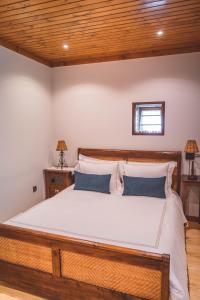 ein Schlafzimmer mit einem großen Bett und einer Holzdecke in der Unterkunft Casa das Santiagas em Arouca in Arouca + 13 Fotos