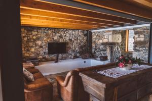 ein Wohnzimmer mit Sofa und Fernseher in der Unterkunft Casa das Santiagas em Arouca in Arouca