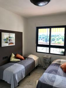 1 dormitorio con 2 camas y 2 ventanas en Luxurious apartment seafront Moraira, en Moraira