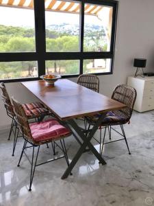 una mesa de comedor con sillas y un tazón. en Luxurious apartment seafront Moraira, en Moraira