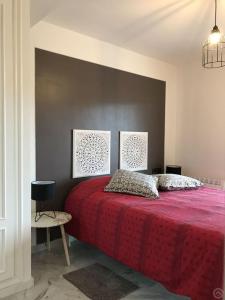 1 dormitorio con 1 cama roja y 2 cuadros en la pared en Luxurious apartment seafront Moraira, en Moraira