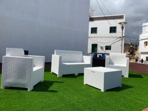 a group of chairs and a table on the grass at Beach House Tajao in La Jaca