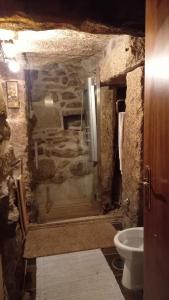ein Steinbad mit einer Dusche und einem WC in der Unterkunft Stone House in Vila Real