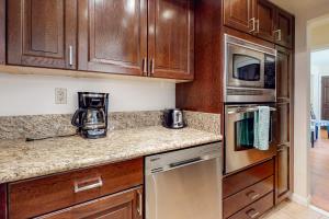 a kitchen with wooden cabinets and stainless steel appliances at Caballeros Condo in Palm Springs
