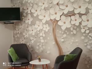 a wall mural of a tree with white flowers at Studios Ana Mari in Komiža