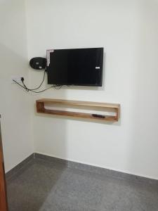 Elle comprend une télévision à écran plat suspendue au mur. dans l'établissement JJ Holiday Homes, à Canaguinim