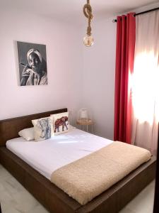 ヘレス・デ・ラ・フロンテーラにあるApartamento La Habana Viejaのベッドルーム1室(赤いカーテン付きの大型ベッド1台付)