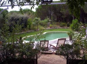 twee stoelen naast een zwembad bij Les Glycines in Grimaud