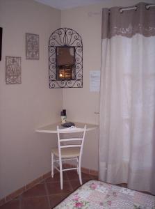 een slaapkamer met een tafel, een stoel en een spiegel bij Les Glycines in Grimaud