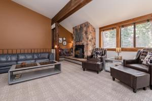 sala de estar con muebles de cuero y chimenea de piedra. en Helios 11N, en Mammoth Lakes