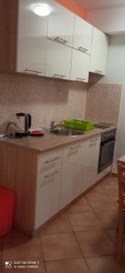 a kitchen with white cabinets and a sink at Studios Ana Mari in Komiža