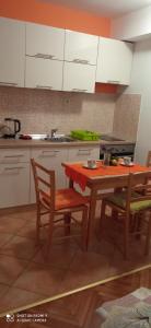 a kitchen with a table and chairs and a sink at Studios Ana Mari in Komiža