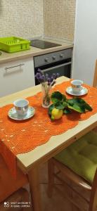 a kitchen table with two cups and plates on it at Studios Ana Mari in Komiža