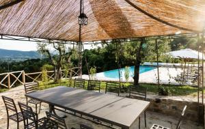 uma mesa e cadeiras em frente a uma piscina em Casa Uliveto in Molino Vitelli em Casella