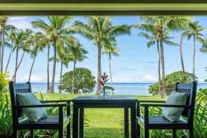 a table with two chairs and a view of the ocean at Shangri-La Yanuca Island, Fiji in Voua