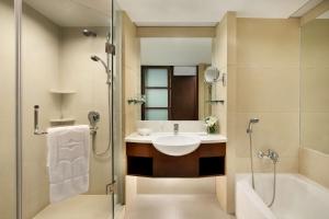 a bathroom with a tub, sink and mirror at Shangri-La Qingdao in Qingdao