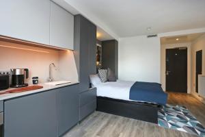 1 dormitorio pequeño con 1 cama y cocina en ALTIDO at VITA Fountainbridge - Adults only, en Edimburgo